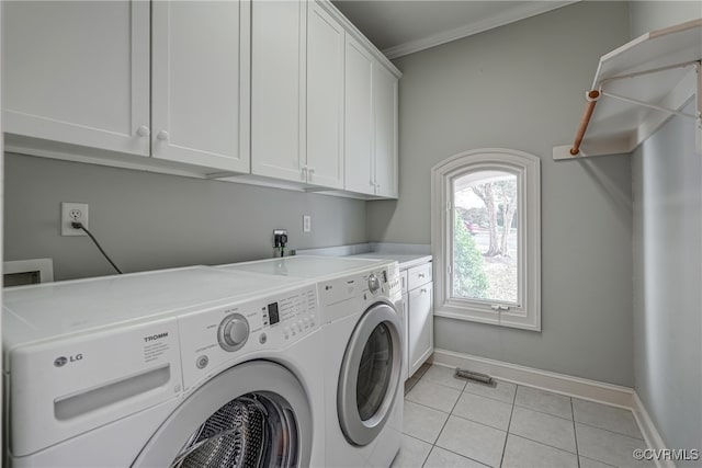 laundry room with washing machine and clothes dryer, light tile patterned flooring, cabinets, and ornamental molding