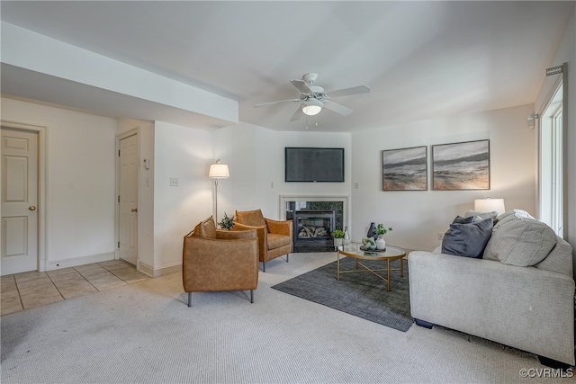 living room featuring light carpet, ceiling fan, and a premium fireplace