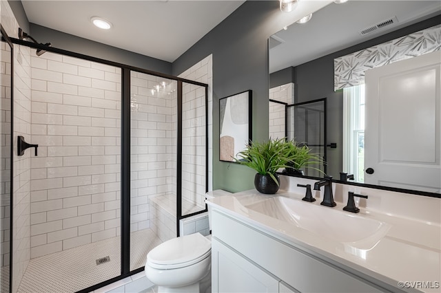 bathroom featuring toilet, vanity, tile patterned flooring, and walk in shower