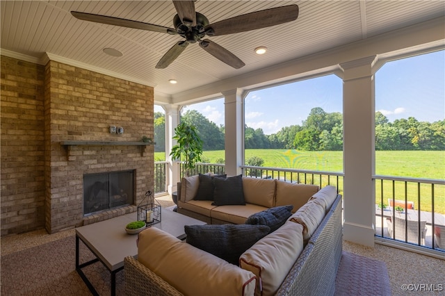 view of patio with ceiling fan, a rural view, and an outdoor living space with a fireplace