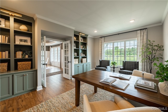 office area with wood-type flooring, crown molding, built in features, and french doors