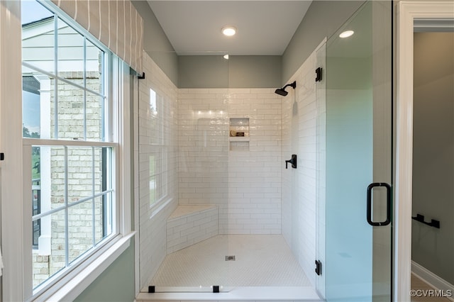 bathroom with an enclosed shower and a healthy amount of sunlight