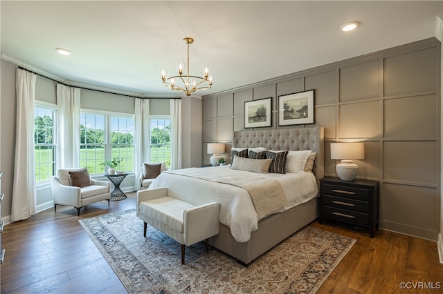 bedroom featuring dark wood-type flooring, an inviting chandelier, and crown molding