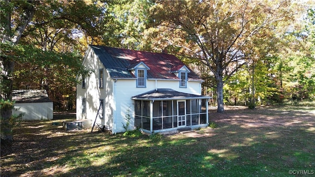 back of house with a sunroom and a yard