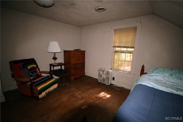 bedroom featuring vaulted ceiling, a textured ceiling, and dark hardwood / wood-style flooring