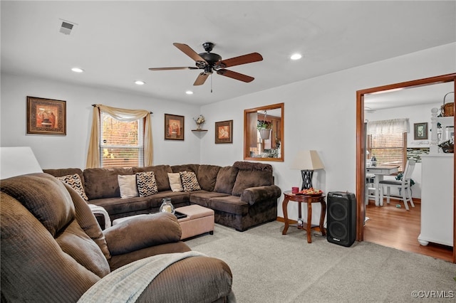 living room with plenty of natural light, ceiling fan, and light wood-type flooring