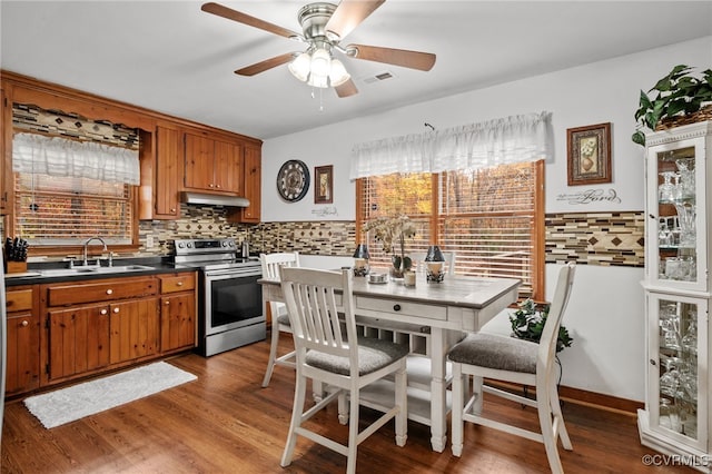 kitchen with backsplash, stainless steel range, ceiling fan, sink, and light hardwood / wood-style flooring