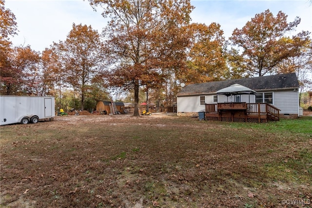 view of yard featuring a storage shed and a wooden deck