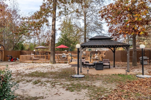 view of yard with a gazebo, a patio, a fire pit, and a deck