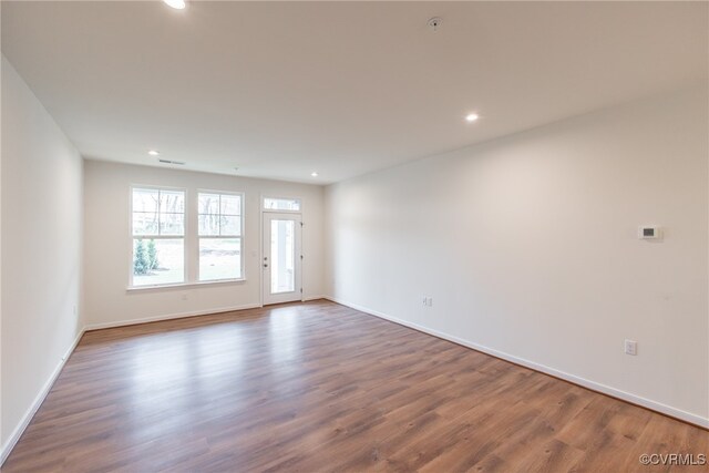 spare room with baseboards, recessed lighting, and wood finished floors