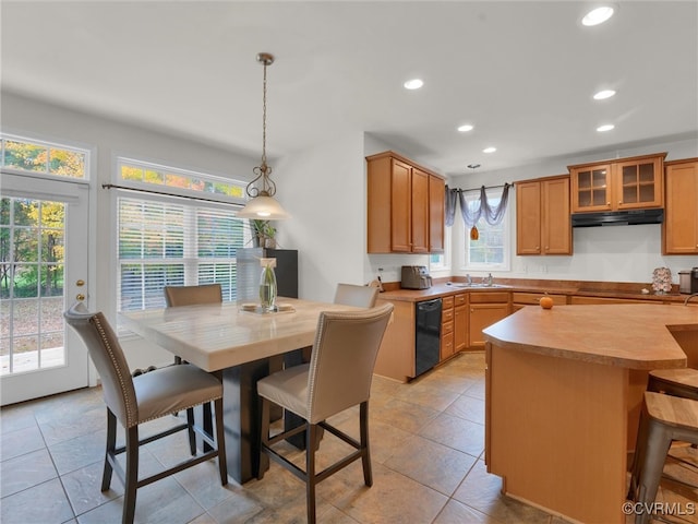 kitchen with a breakfast bar, light tile patterned floors, pendant lighting, and black dishwasher