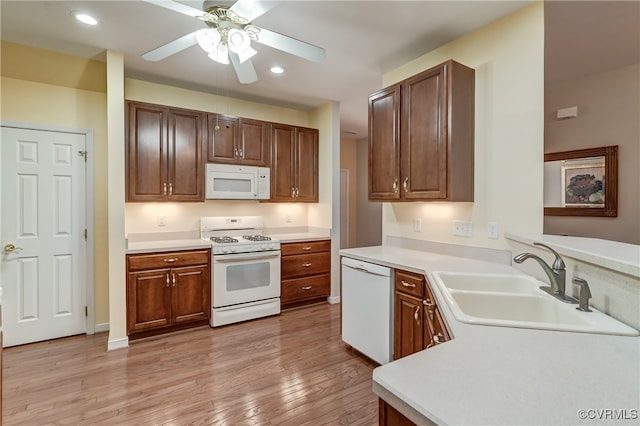 kitchen featuring light hardwood / wood-style flooring, sink, white appliances, and ceiling fan