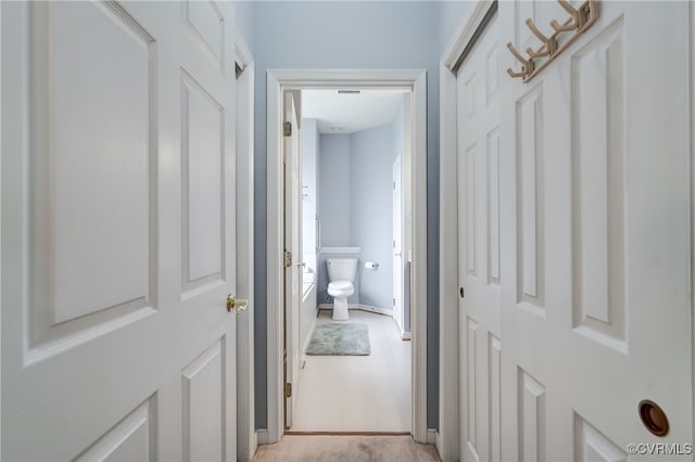 hallway featuring light colored carpet