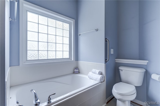 bathroom with plenty of natural light, toilet, and tiled tub