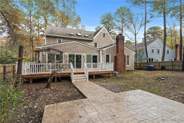 rear view of property featuring a patio area, crawl space, a fenced backyard, and a chimney