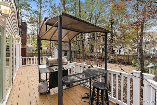 deck with an outbuilding, a grill, and a fenced backyard