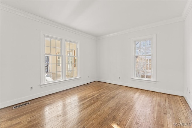 unfurnished room featuring visible vents, crown molding, baseboards, and hardwood / wood-style flooring