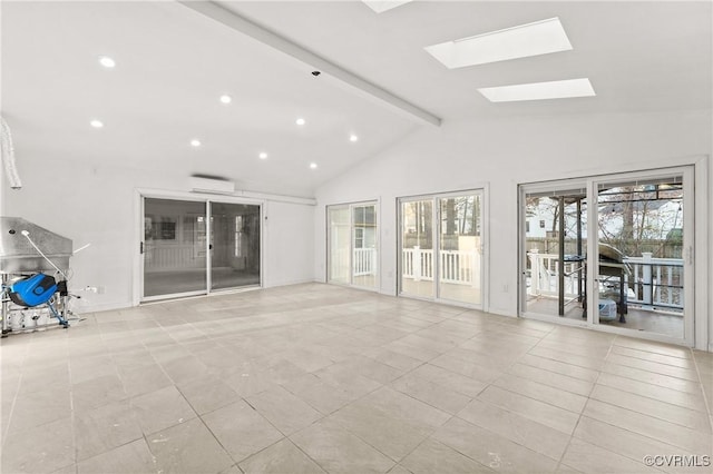 unfurnished living room featuring a wall unit AC, recessed lighting, vaulted ceiling with skylight, light tile patterned floors, and baseboards