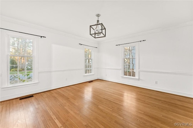 unfurnished dining area featuring a wealth of natural light, visible vents, ornamental molding, and hardwood / wood-style flooring