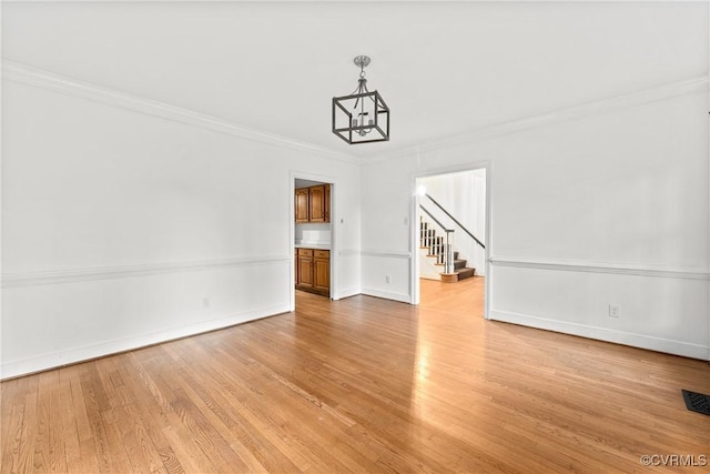 interior space with stairway, baseboards, crown molding, and light wood finished floors