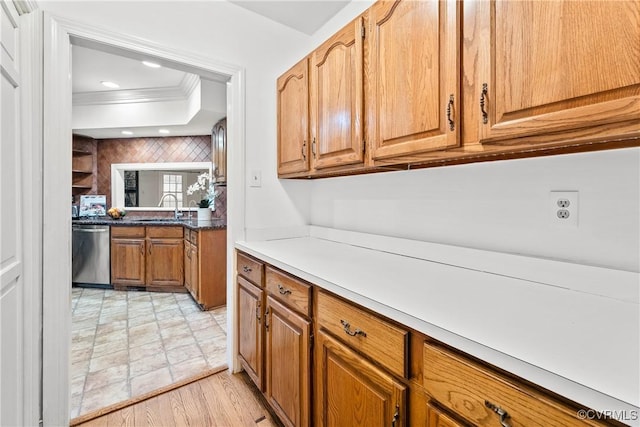 kitchen with ornamental molding, recessed lighting, brown cabinets, stainless steel dishwasher, and a sink