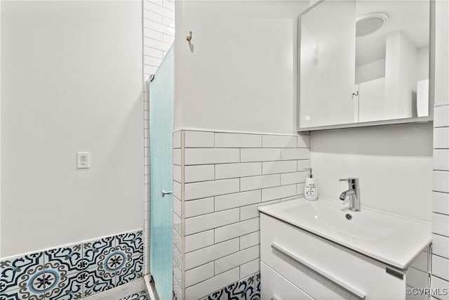 bathroom featuring a shower stall, tile walls, and vanity