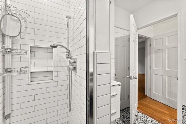 full bathroom with wood finished floors and a shower stall