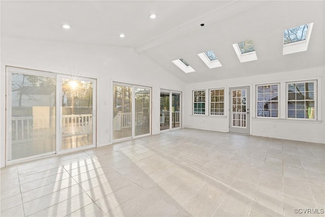 unfurnished sunroom with a wealth of natural light, a skylight, and beam ceiling