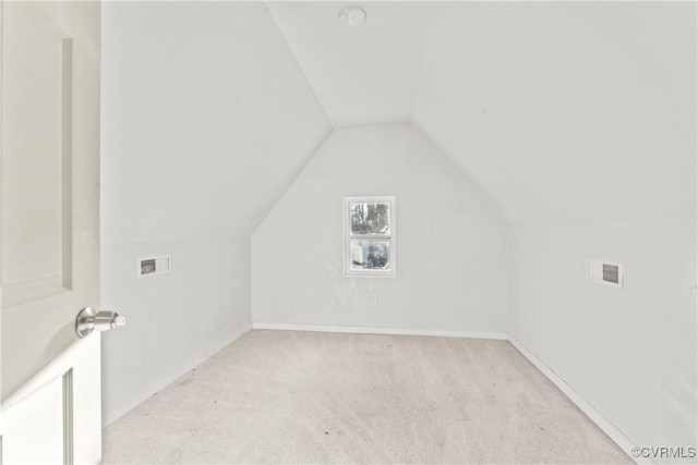 bonus room with light carpet, vaulted ceiling, visible vents, and baseboards