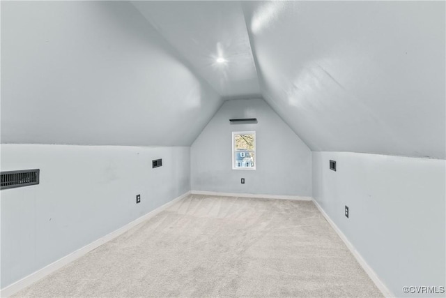 additional living space featuring lofted ceiling, carpet floors, baseboards, and visible vents