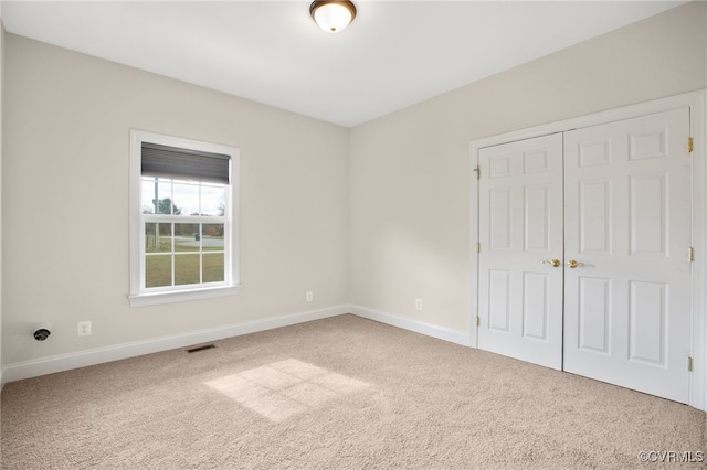 unfurnished bedroom with carpet floors and a closet