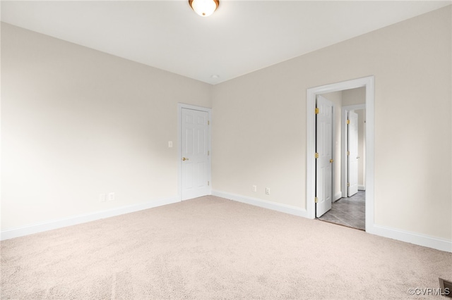 spare room featuring light carpet