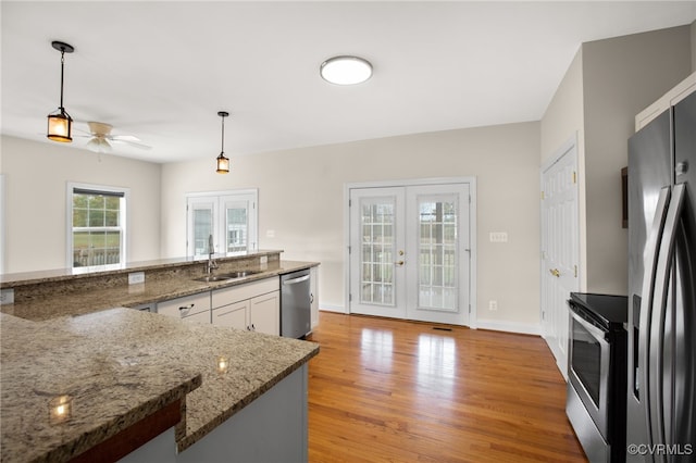 kitchen featuring sink, french doors, pendant lighting, white cabinets, and appliances with stainless steel finishes