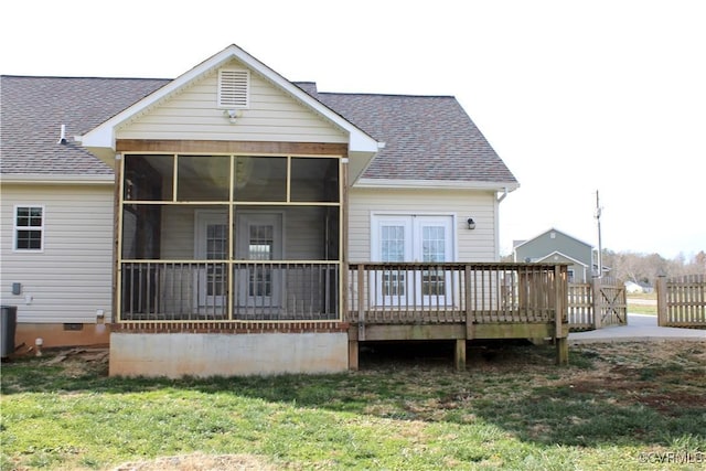 back of property with a yard, a deck, and a sunroom