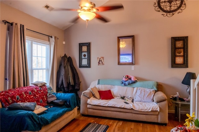 living room featuring ceiling fan, light wood-type flooring, and lofted ceiling