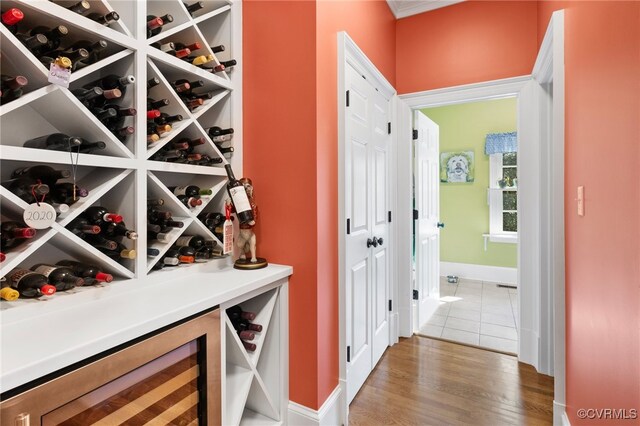 wine cellar with wine cooler and wood-type flooring