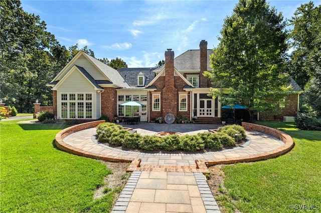 rear view of property with french doors, a lawn, and a patio