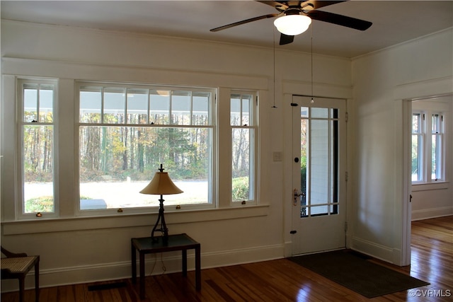 interior space with hardwood / wood-style flooring, ceiling fan, and crown molding