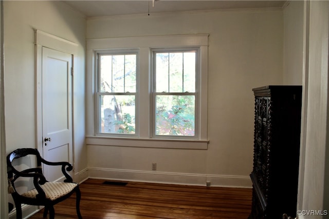 living area featuring dark hardwood / wood-style floors and ornamental molding