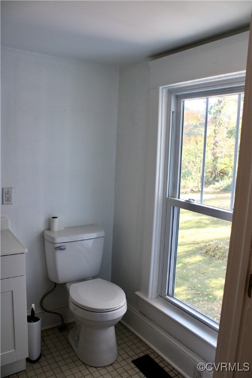 bathroom with a wealth of natural light, vanity, tile patterned floors, and toilet