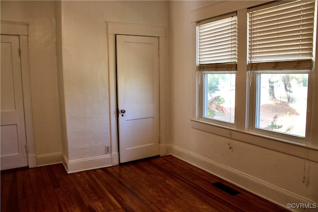 unfurnished bedroom with dark hardwood / wood-style floors