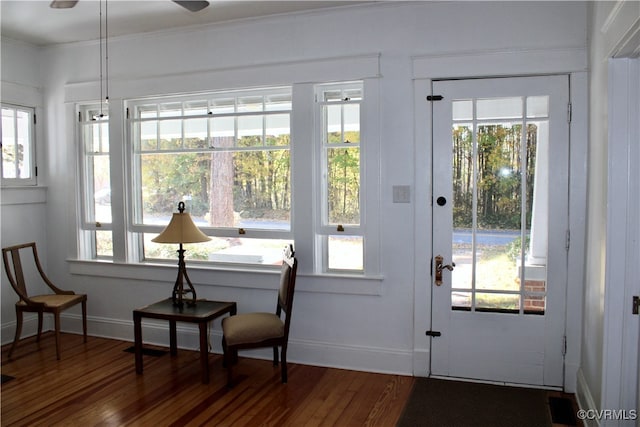 doorway to outside with hardwood / wood-style floors, a healthy amount of sunlight, and crown molding