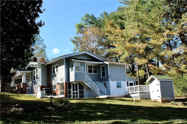 back of house with a shed, a lawn, and central AC