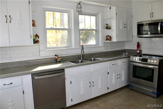 kitchen featuring white cabinets, decorative backsplash, sink, dark tile patterned floors, and appliances with stainless steel finishes