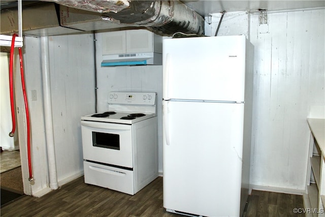 kitchen featuring white cabinets, dark wood-type flooring, wooden walls, and white appliances