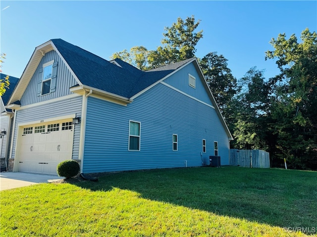 view of side of home with a lawn, a garage, and central air condition unit