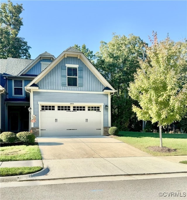 craftsman house with a garage and a front lawn