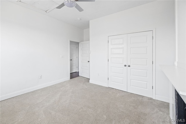 unfurnished bedroom with ceiling fan, a closet, and light carpet