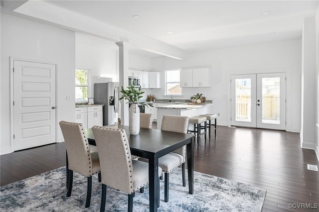 dining space with dark wood-type flooring and a healthy amount of sunlight