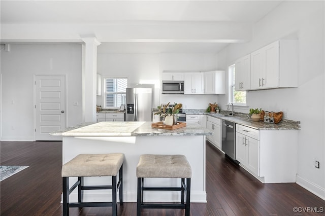 kitchen featuring a wealth of natural light, a kitchen island, and stainless steel appliances